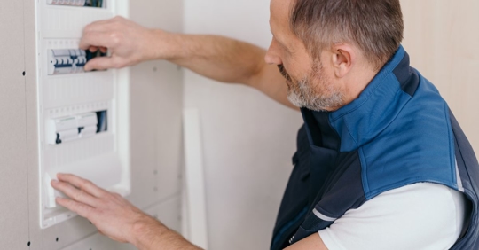 man flipping circuit breakers