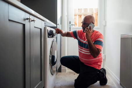man looking at broken appliance